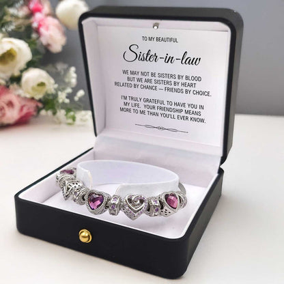 Silver bracelet with purple heart charms in a black box with a message for a sister-in-law.